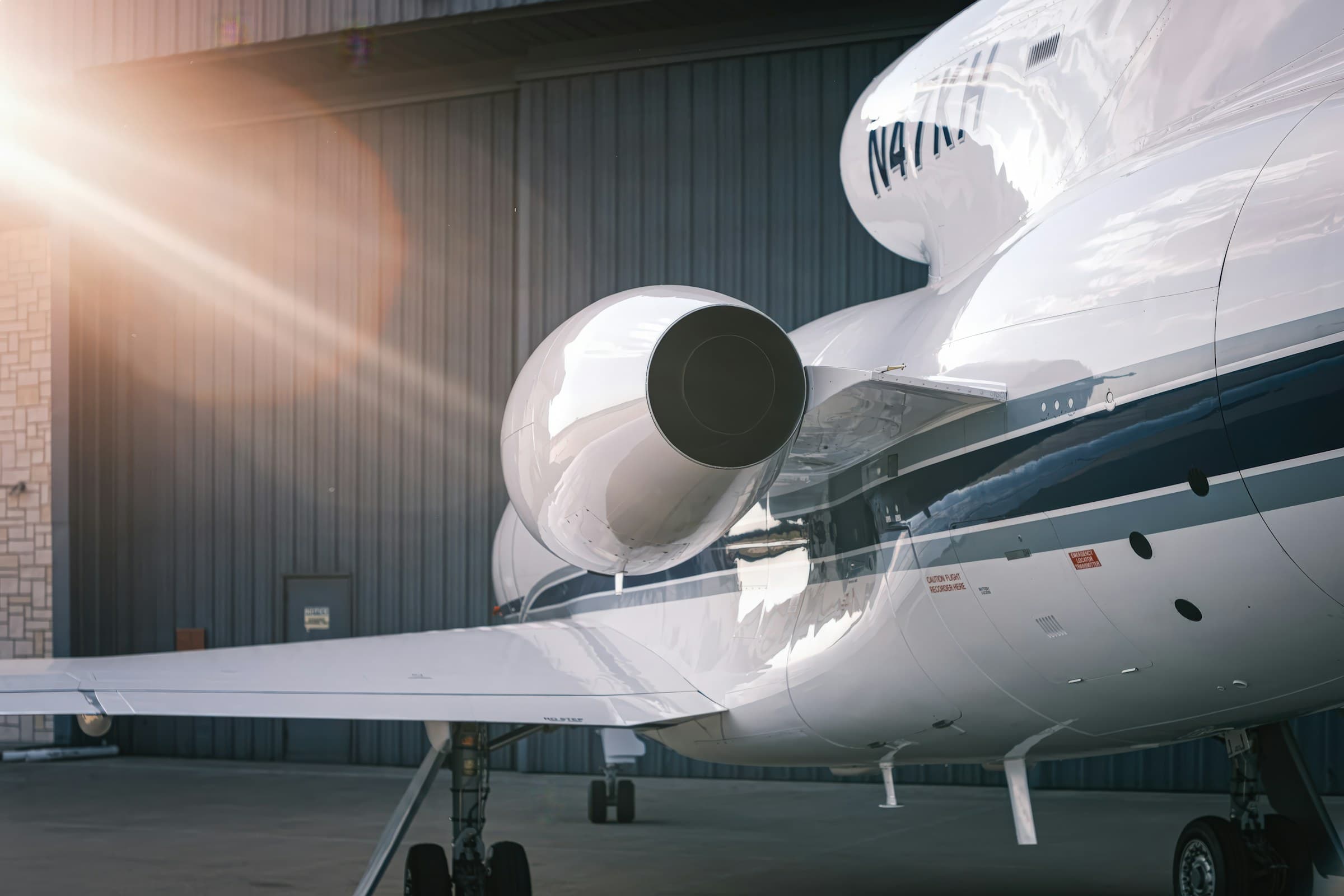 Private jet with custom FAA N-number N47KH painted on the engine nacelle, hangar-kept at golden hour