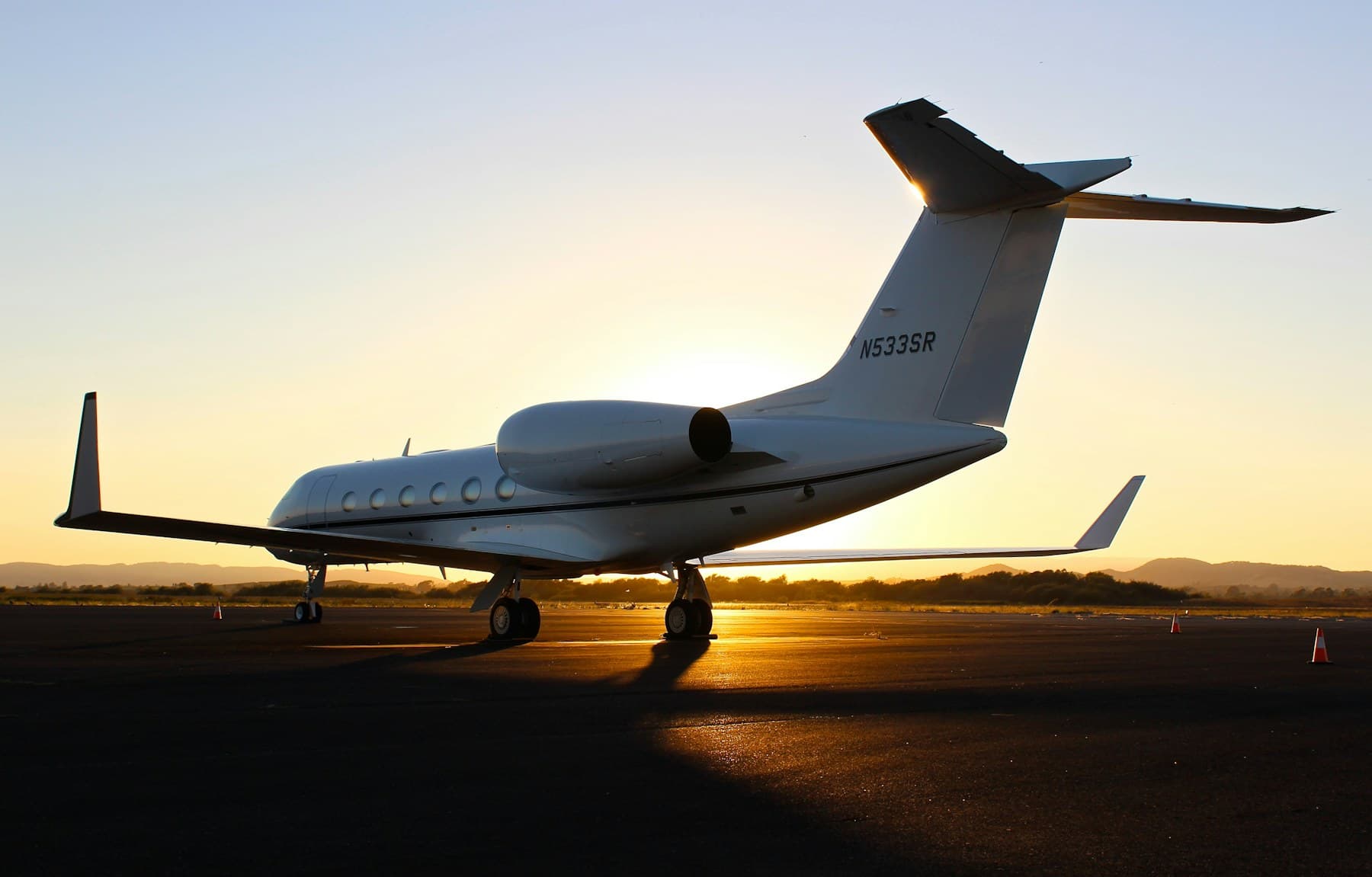 Gulfstream private jet with FAA N-number N533SR on the tail, parked on the tarmac at golden hour